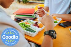 Teenagers eating packed lunches in school canteen close up of plates books and table